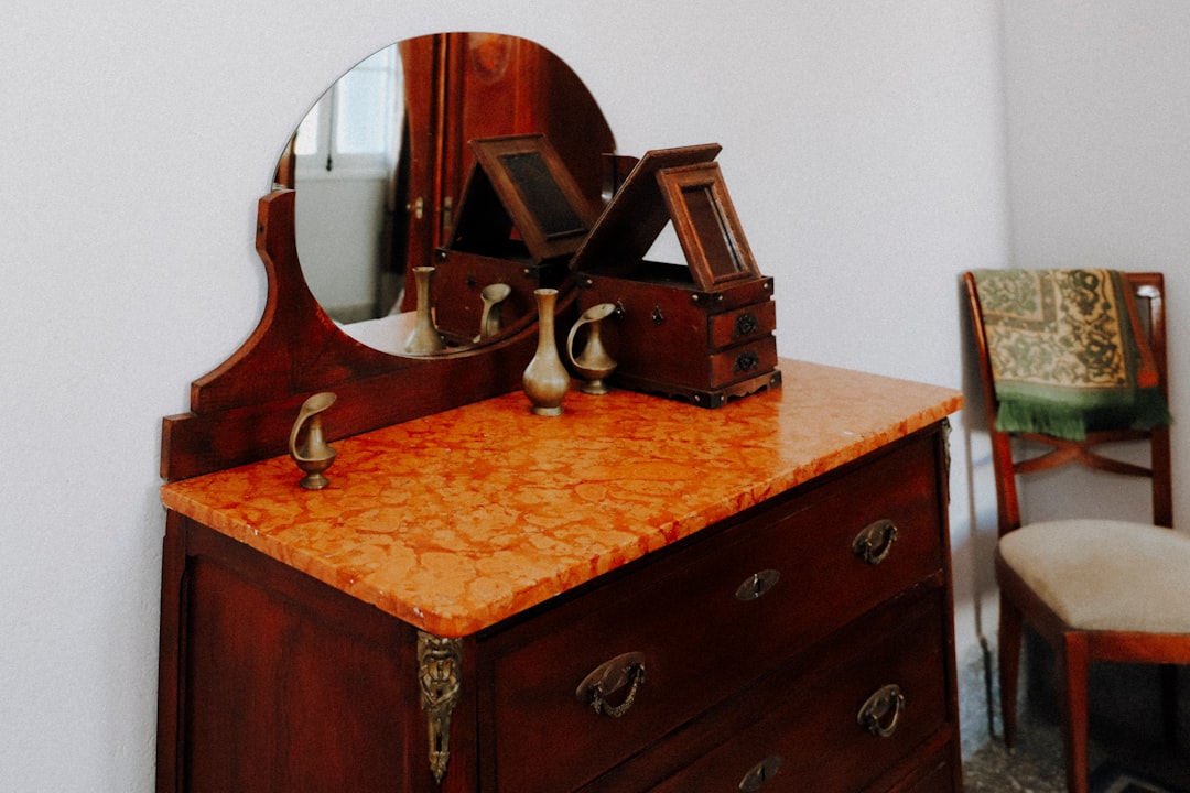 brown wooden framed mirror on brown wooden drawer