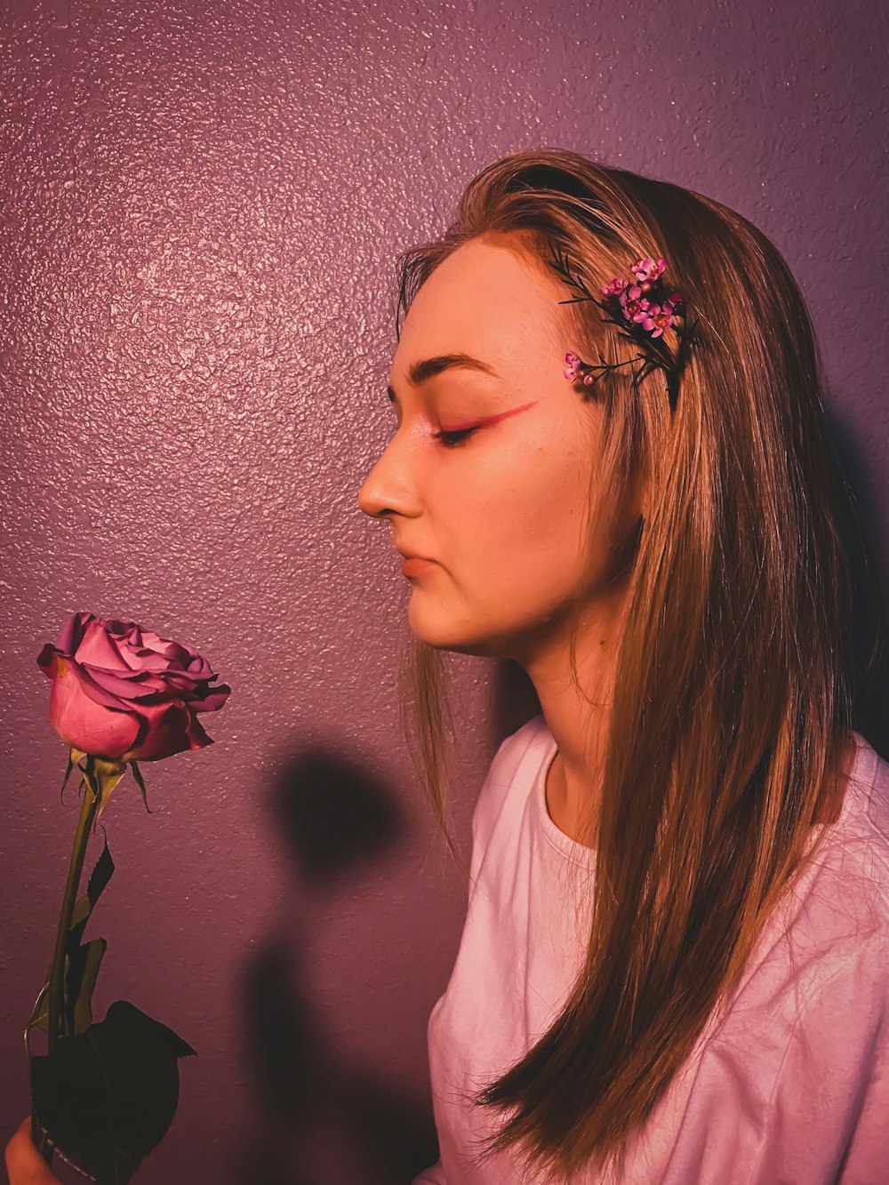 woman in white crew neck shirt with pink flower on her ear