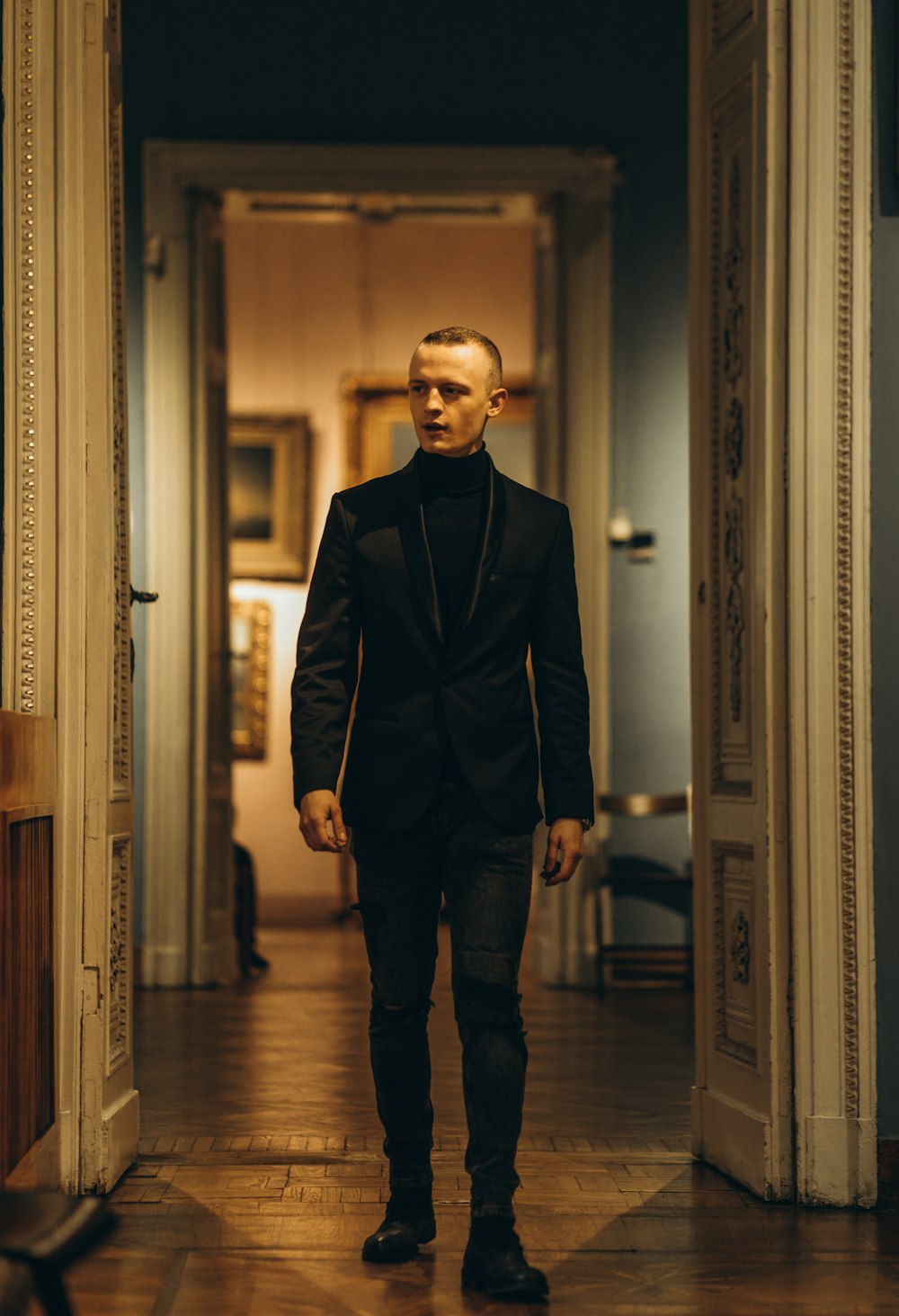 man in black suit standing on hallway
