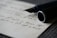A close-up of a sleek Padbergpen held in a customer's hand, writing on crisp white paper.