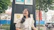 Smiling woman standing proudly next to a colorful, eye-catching storefront sign designed and printed by Vivaforma.