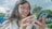 A happy woman using her phone to make an insurance payment.