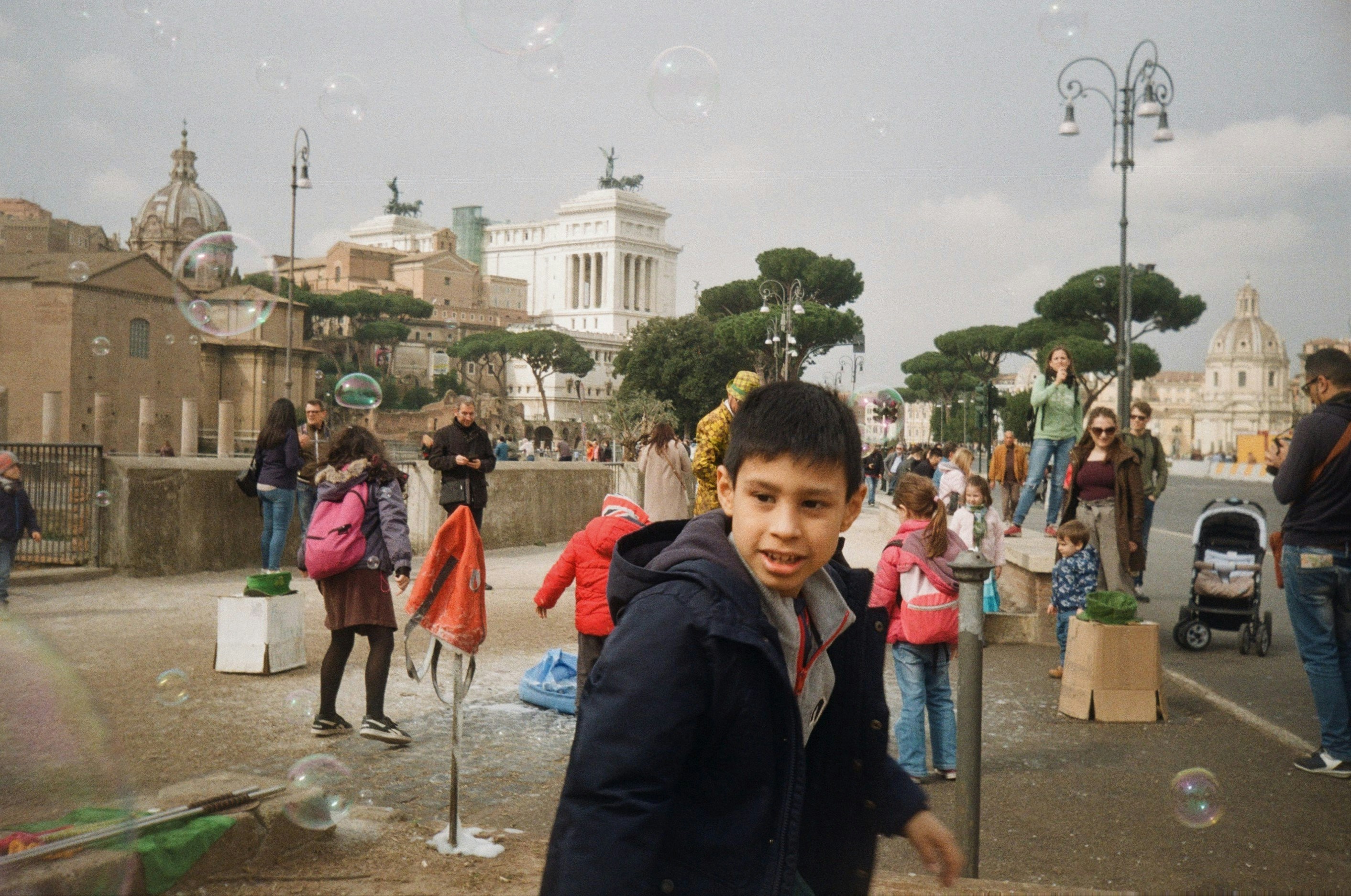 boy in black jacket standing near people during daytime