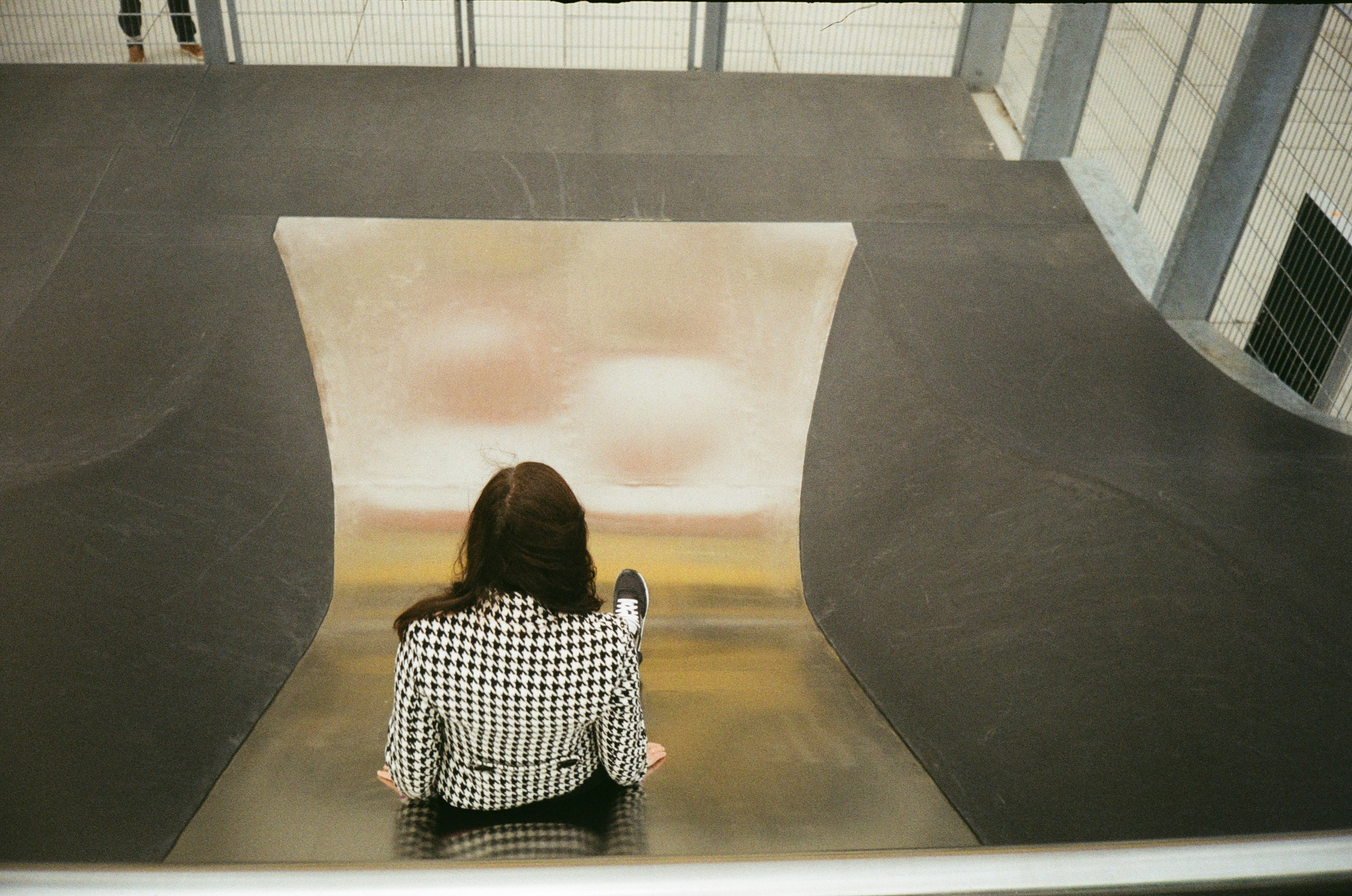 woman in black and white checkered dress sitting on black and white bench