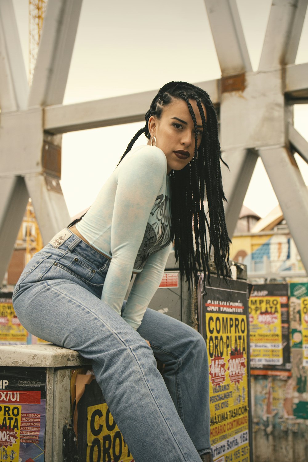 woman in white long sleeve shirt and blue denim jeans sitting on brown wooden bench during