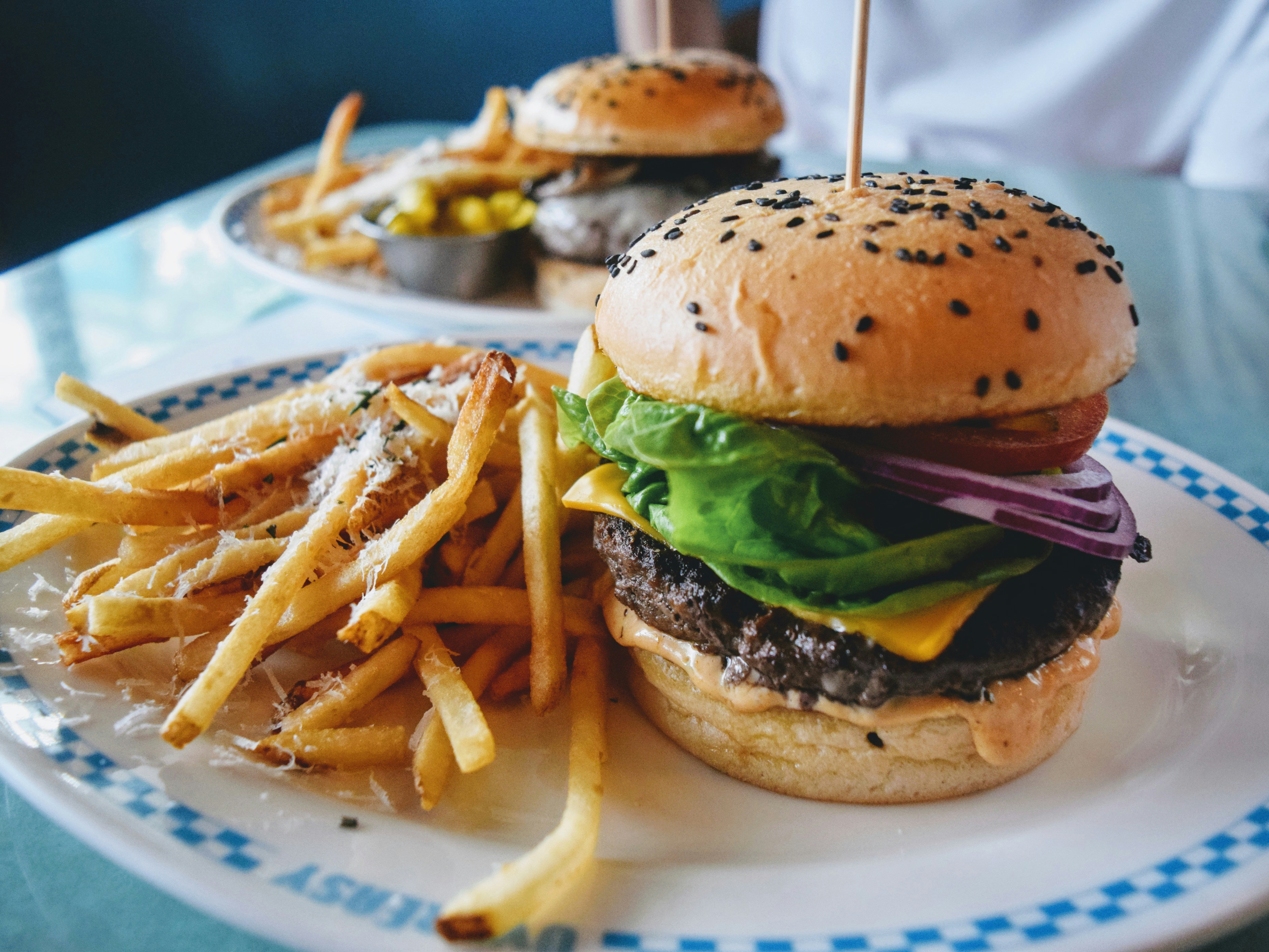 burger with lettuce and tomato on white ceramic plate, 
