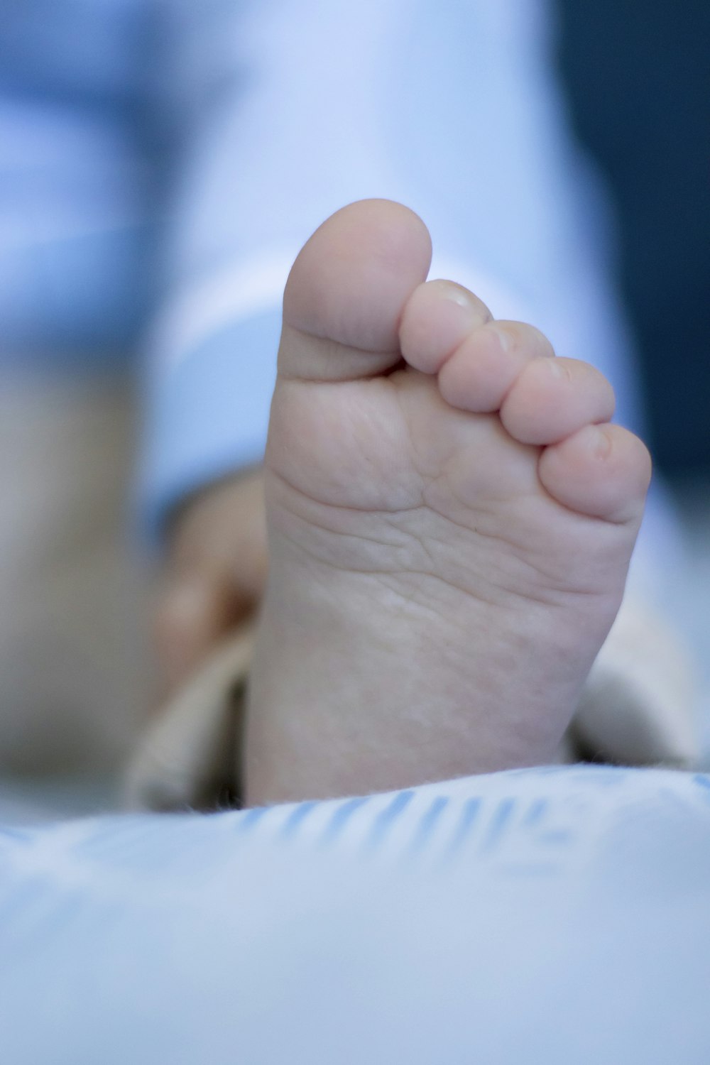 persons feet on white textile