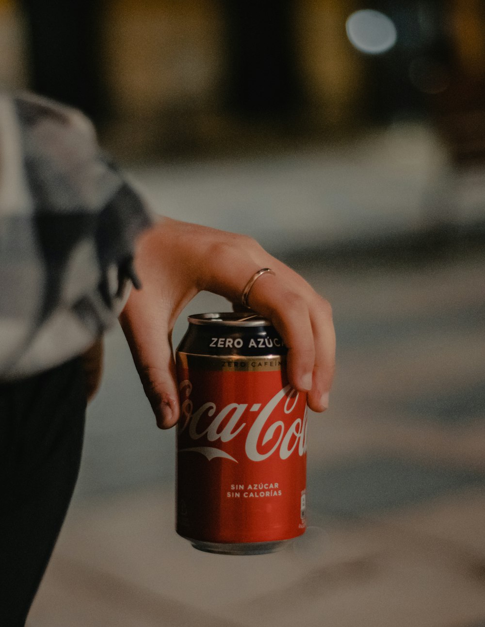 coca cola zero can on persons hand