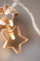 Golden stars softly illuminating a serene crystal altar in warm beige tones.