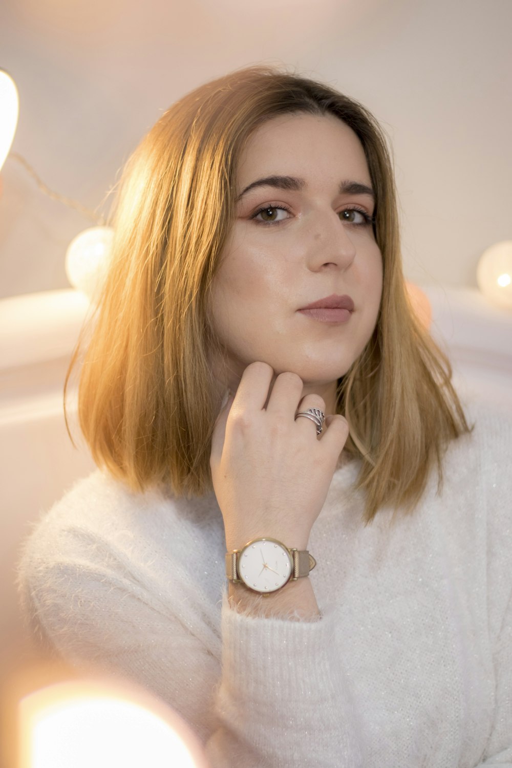 woman in white sweater wearing white round analog watch