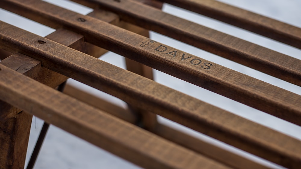 a close up of a wooden bench with writing on it