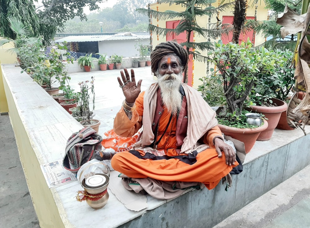 woman in orange dress sitting on concrete bench during daytime