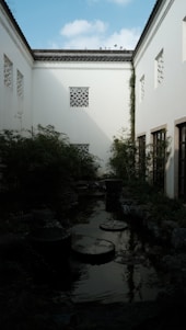 A tranquil courtyard of Swaminarayan Bhakti Dham bathed in soft morning light with blooming flowers.