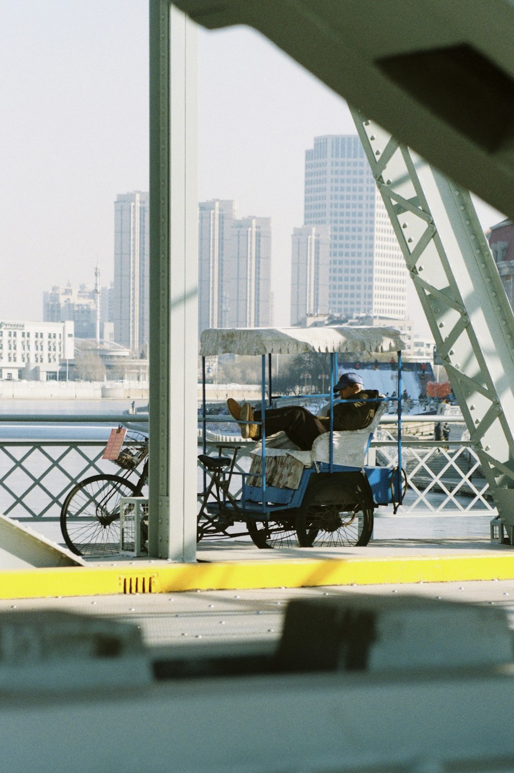 man in blue shirt riding on black and blue trike during daytime
