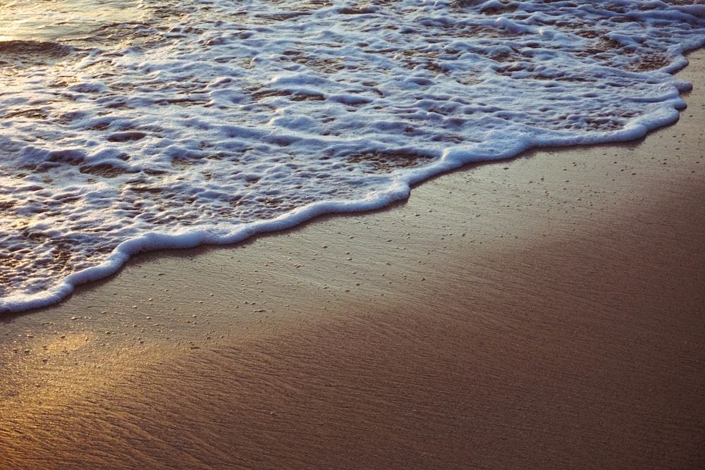 sea waves crashing on shore during daytime