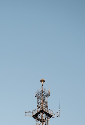Exterior shot of a tall communication tower standing against a clear blue sky.