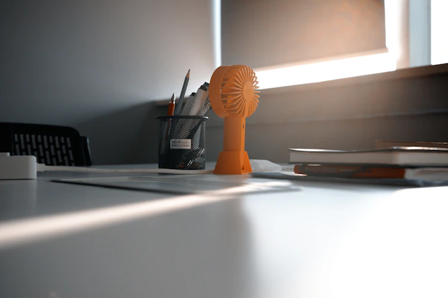 A serene desk by a window with a notebook, pen, and soft natural light.