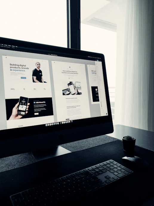Creative workspace with computer screens showing web design and development projects.