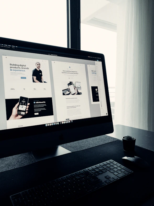 A creative workspace with a laptop displaying a vibrant website design in progress.