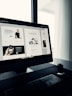 A designer crafting a sleek website layout on a high-resolution screen in a modern office.