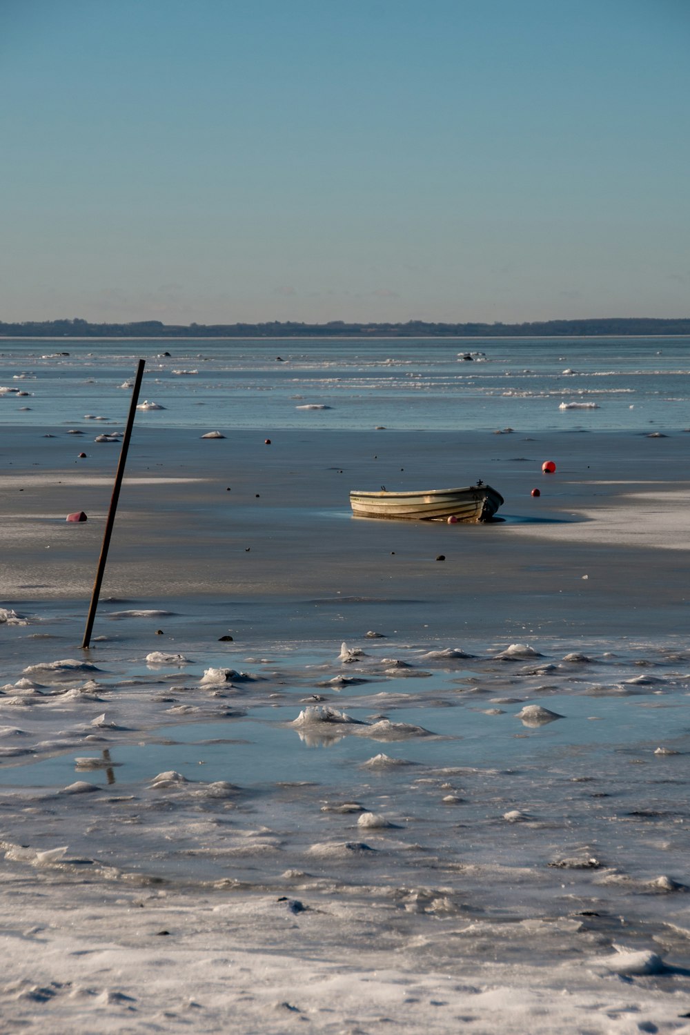 white and black boat on white snow covered ground during daytime