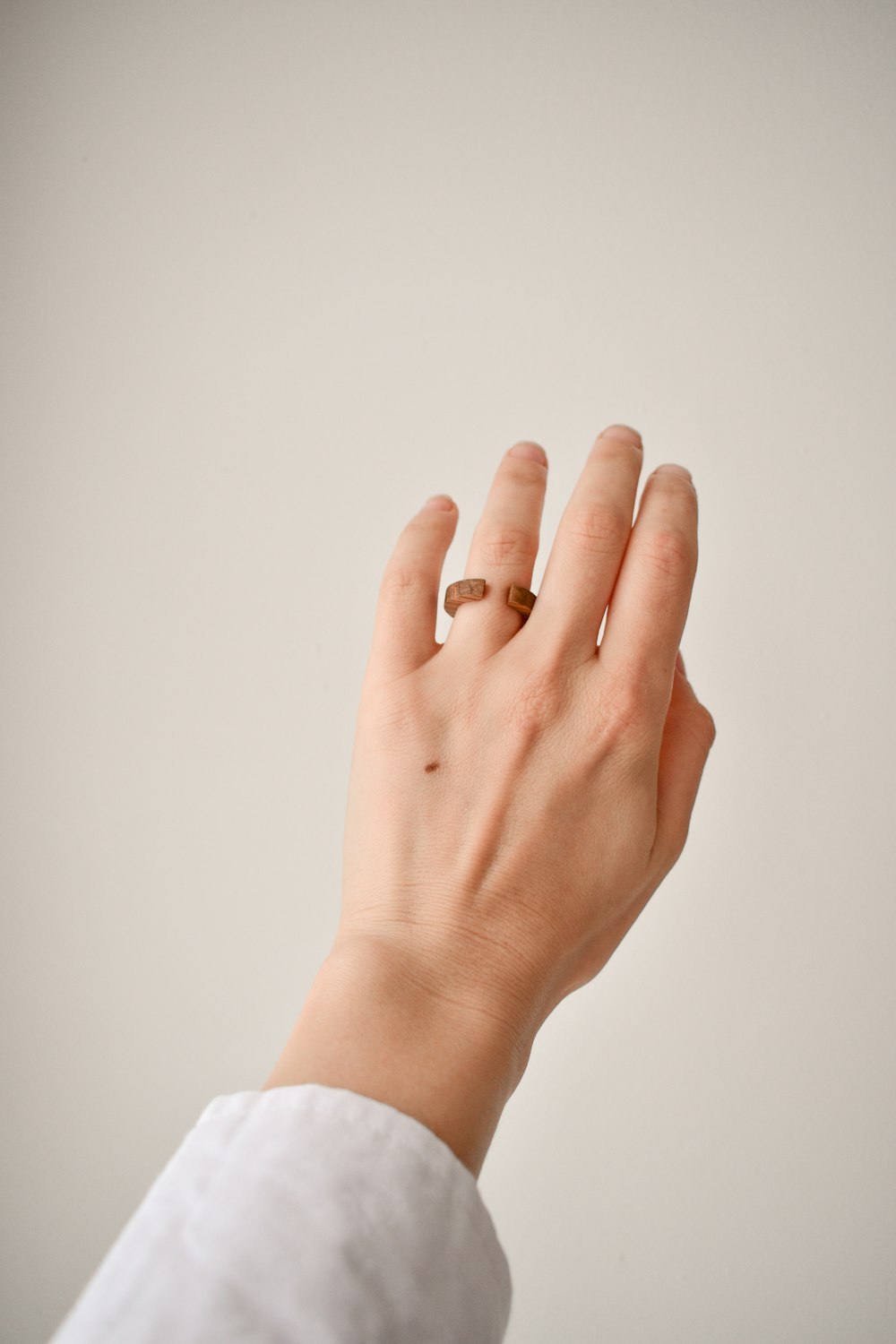 person wearing silver ring with white manicure