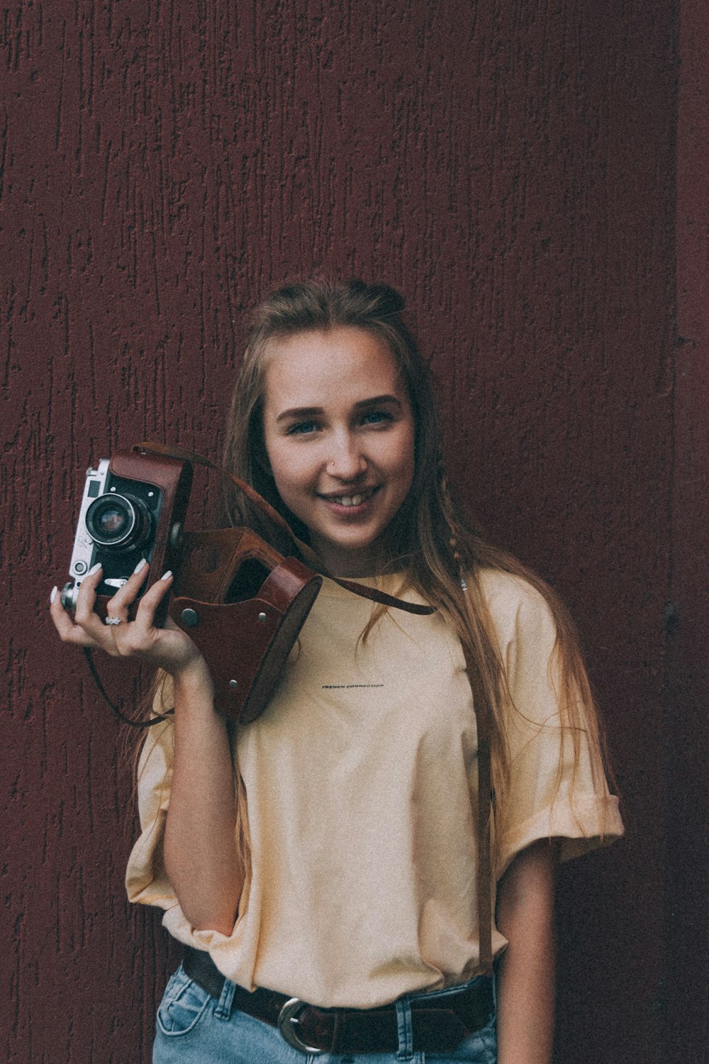 woman in brown coat holding camera