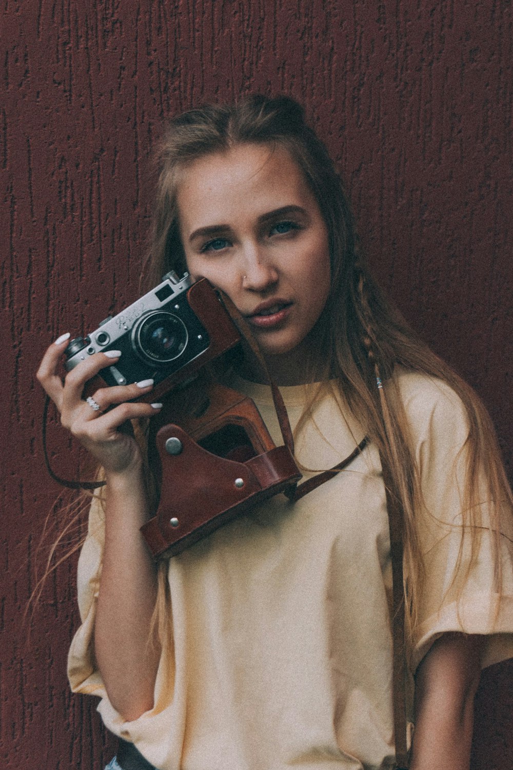 a woman holding a camera up to her face