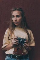 woman in white shirt holding black camera