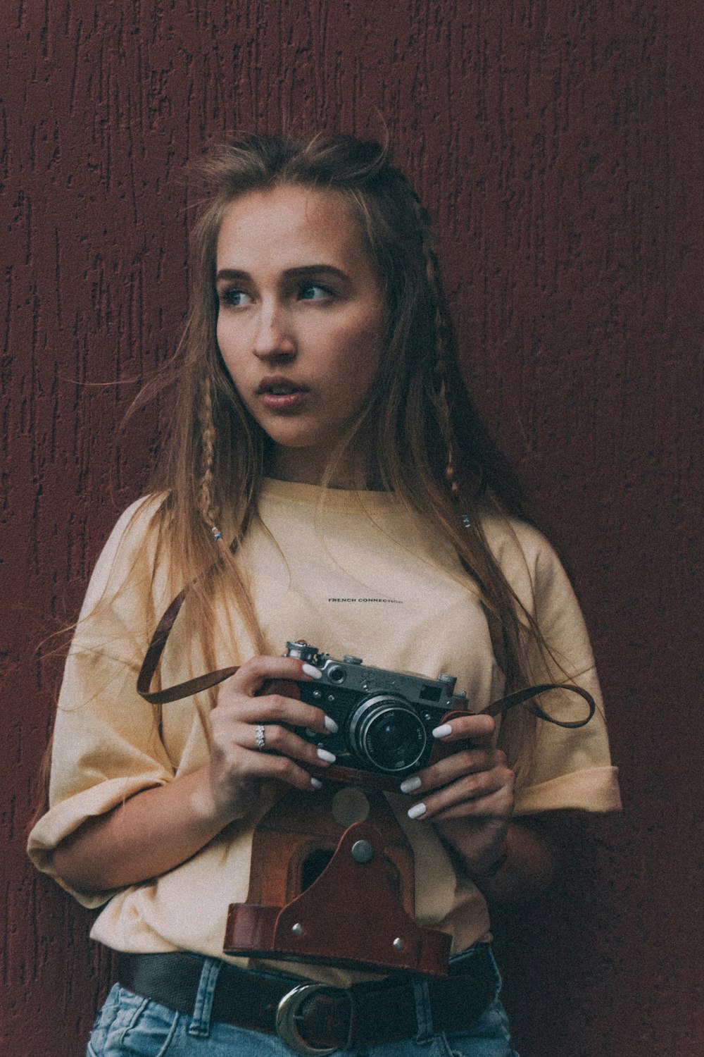 woman in white shirt holding black camera