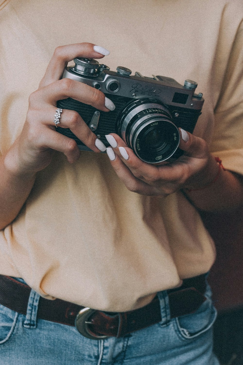 person holding black and silver camera