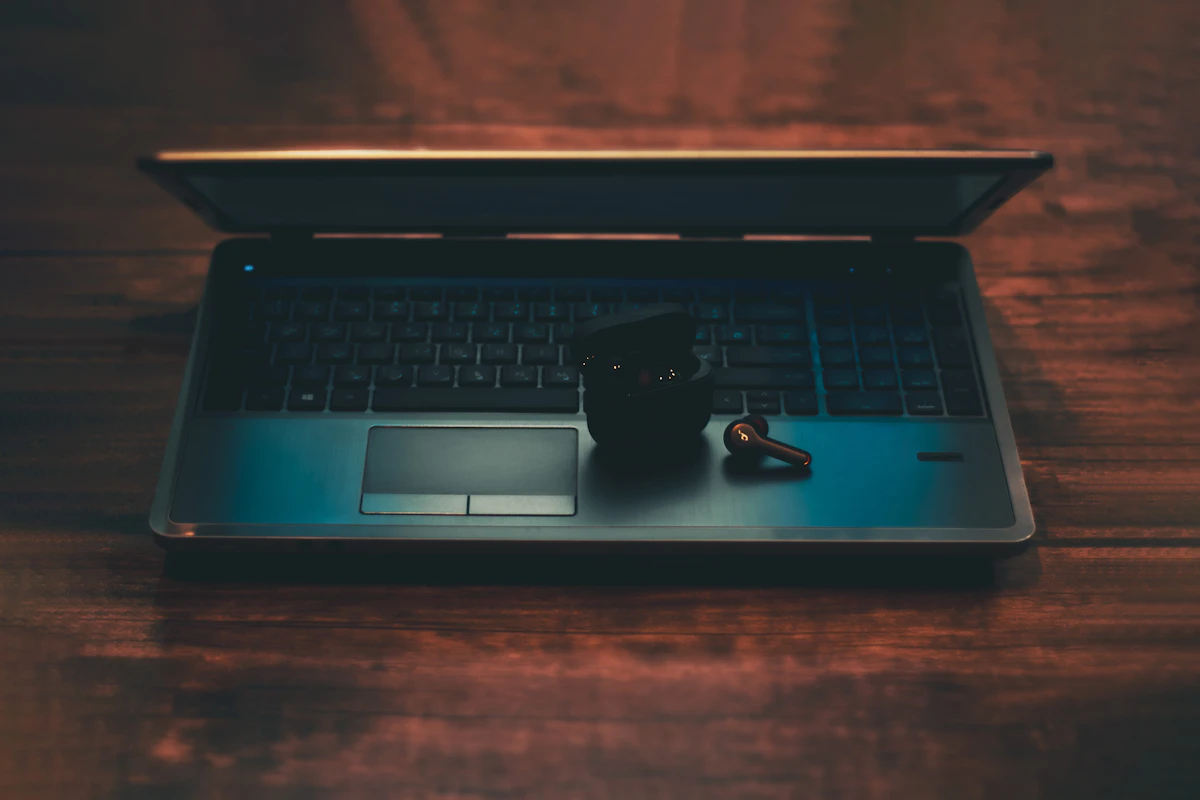 Laptop dan mouse di atas meja kayu