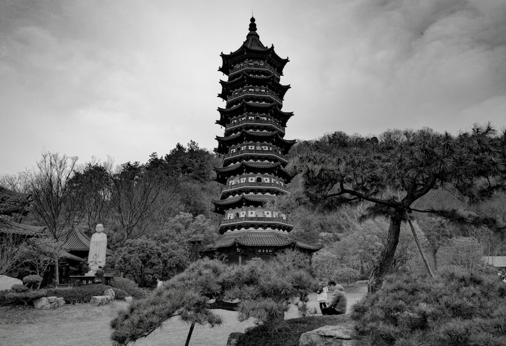 grayscale photo of temple surrounded by trees