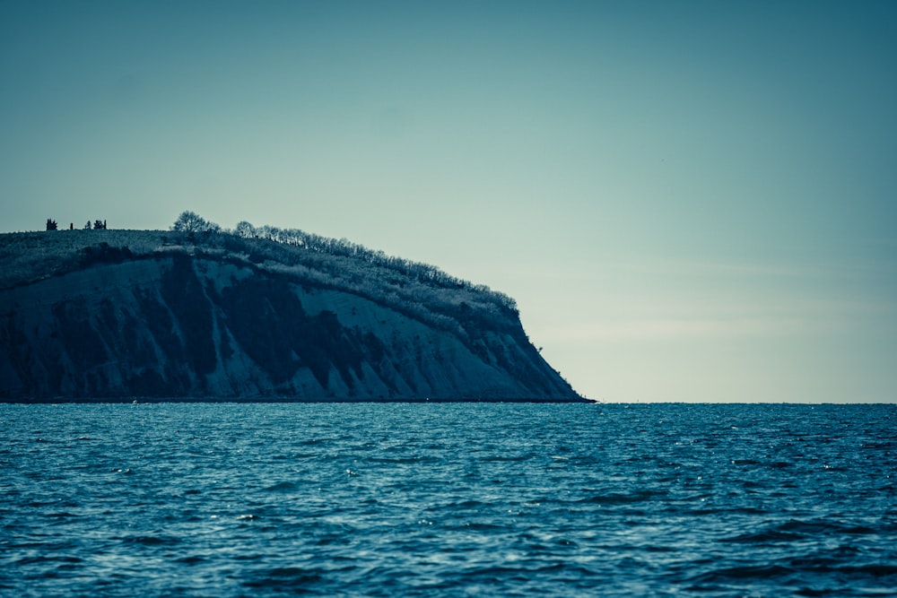 Montaña marrón y verde junto al mar durante el día