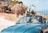 A couple enjoying a scenic drive on a sunny day with their rental car.