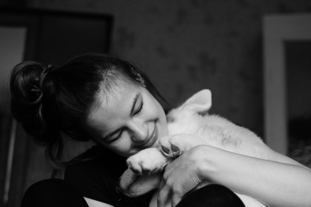 grayscale photo of woman hugging dog