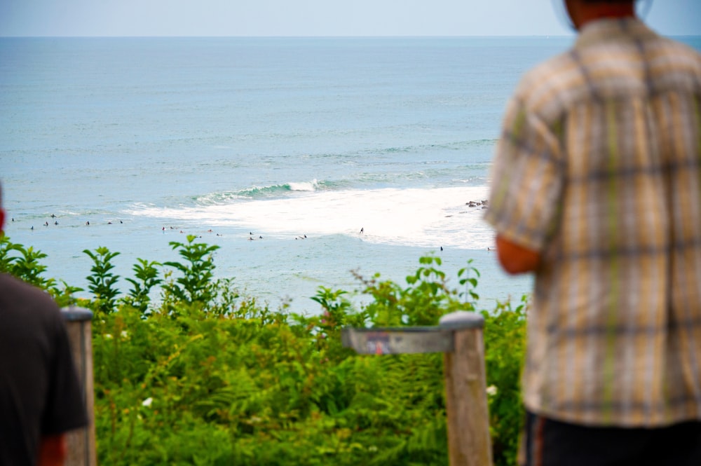 person in brown shirt standing on seashore during daytime