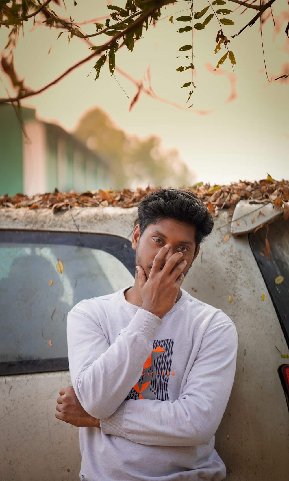 man in white crew neck t-shirt holding his face