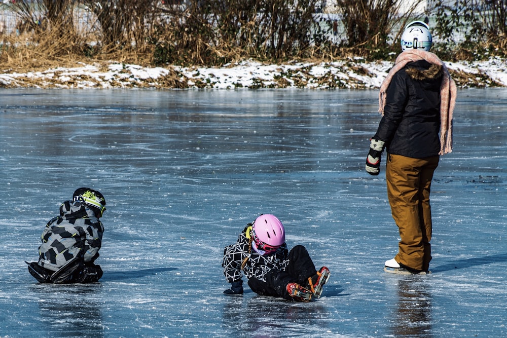 man in black jacket and black pants wearing pink helmet sitting on water during daytime