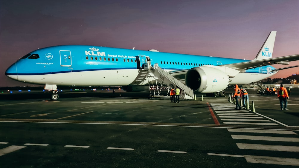 white and blue airplane on airport during daytime