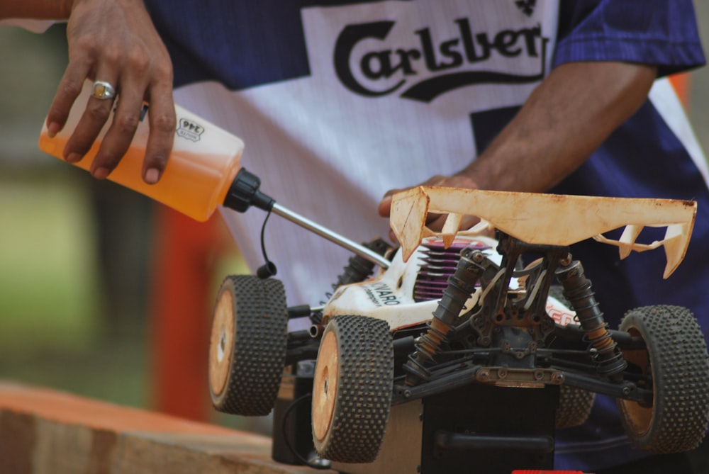 person holding orange and black power tool