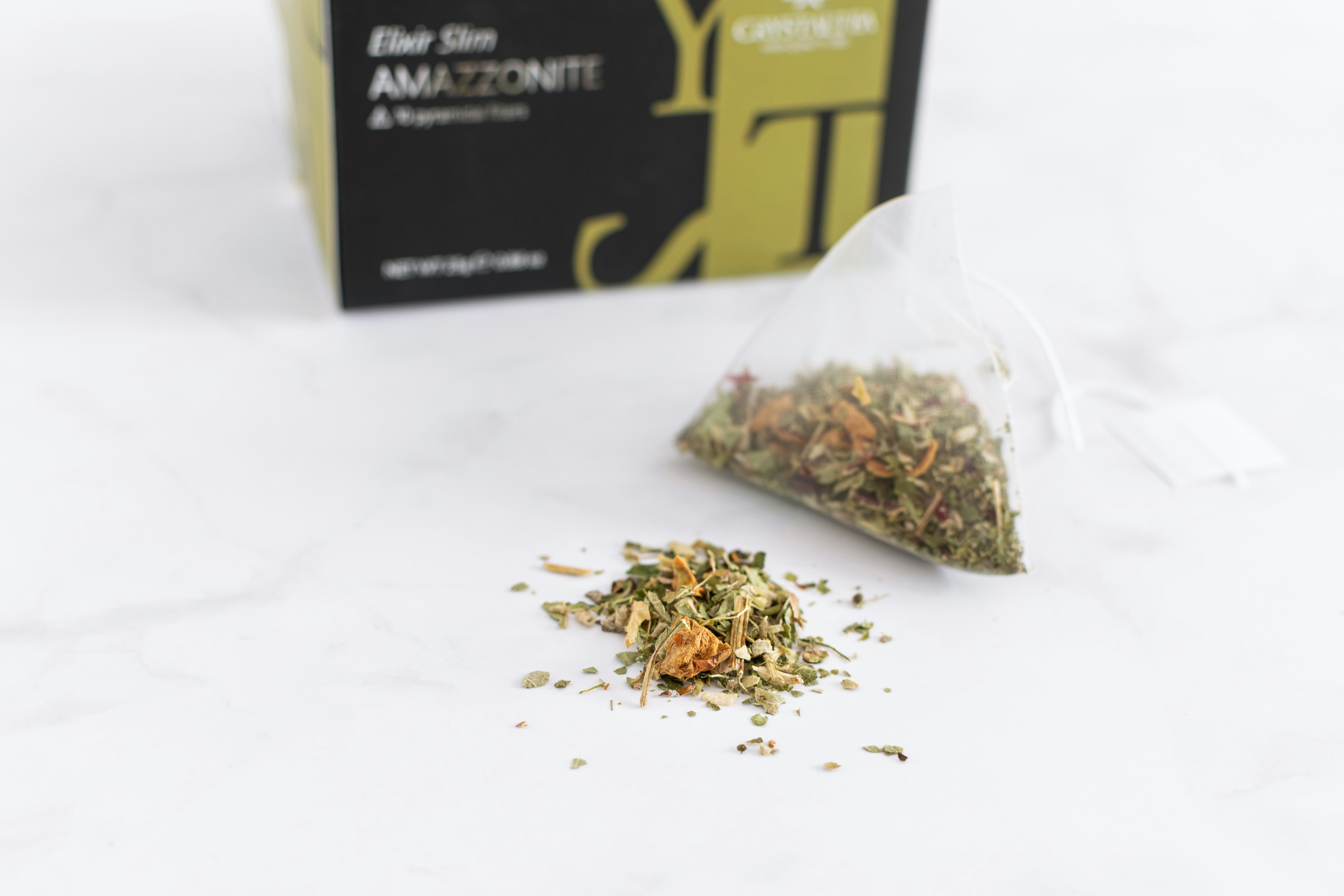 Premium herbal tea collection in elegant packaging with loose leaf herbs scattered around