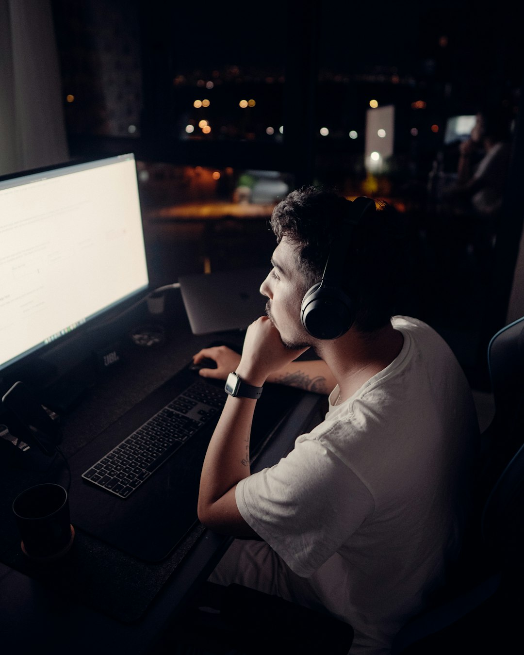 man in white t-shirt using black laptop computer