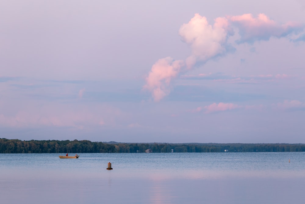 person in white kayak on body of water during daytime