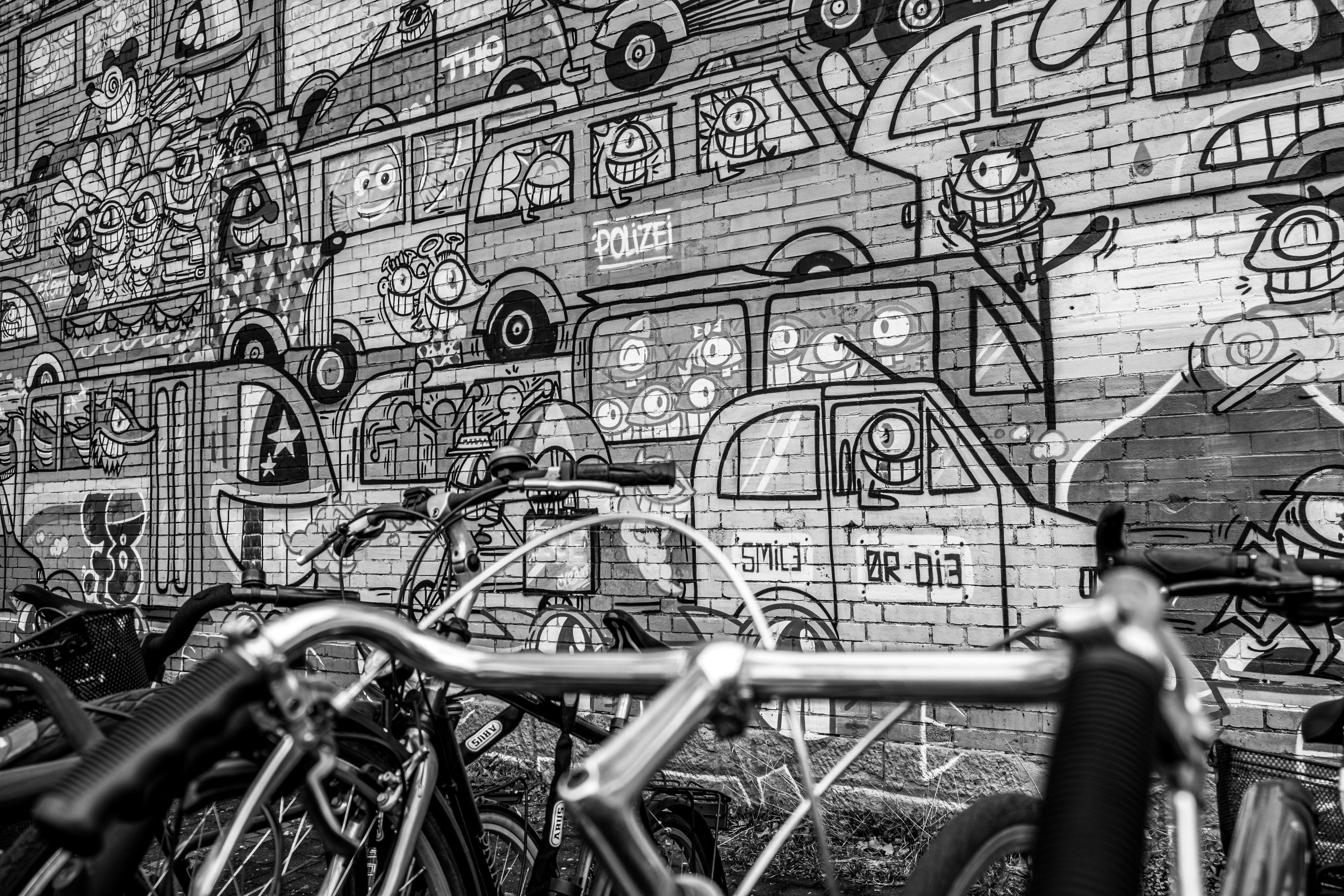 bicycle parked beside wall with graffiti