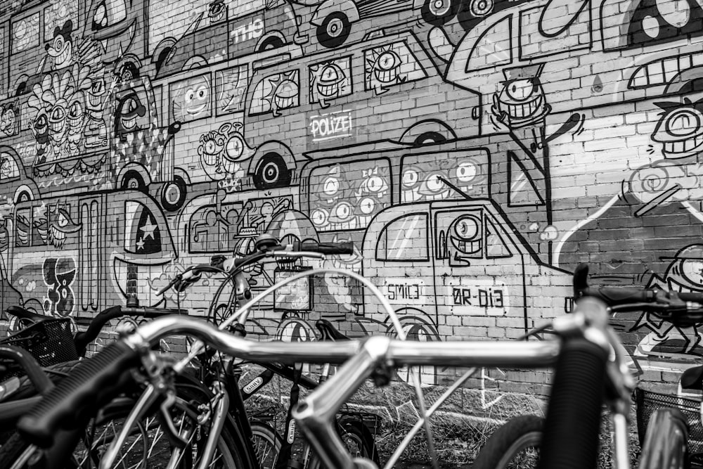 bicycle parked beside wall with graffiti