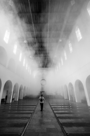 man in black jacket walking on hallway