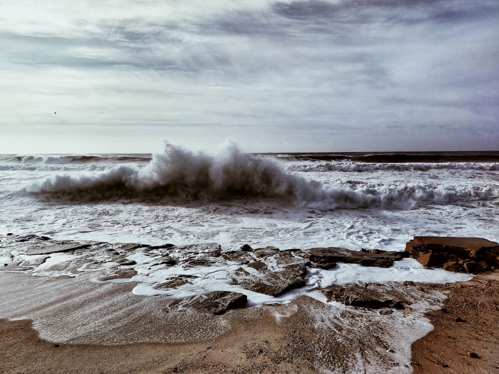 ocean waves crashing on shore during daytime