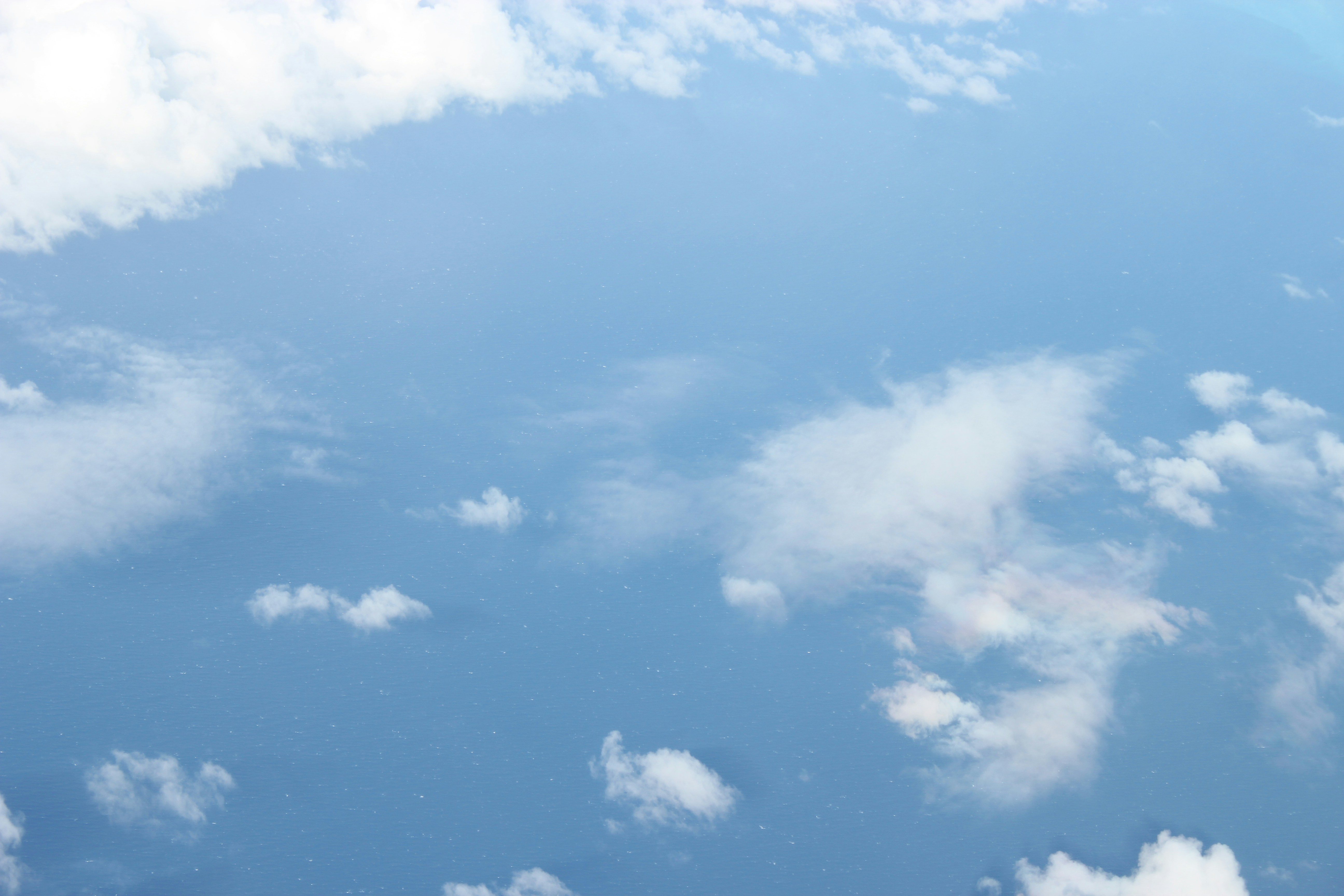 Earth from orbit, blue ocean with white clouds, dark space, sunlit horizon arc