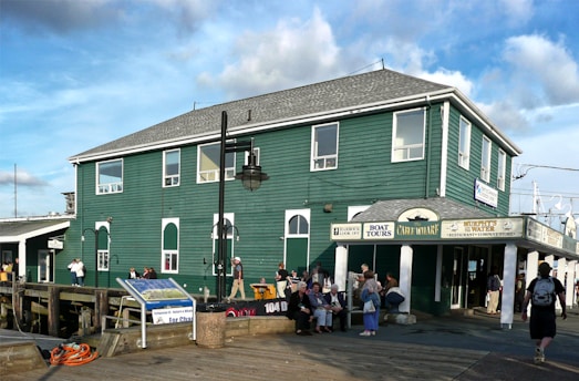 people standing in front of green and white building during daytime